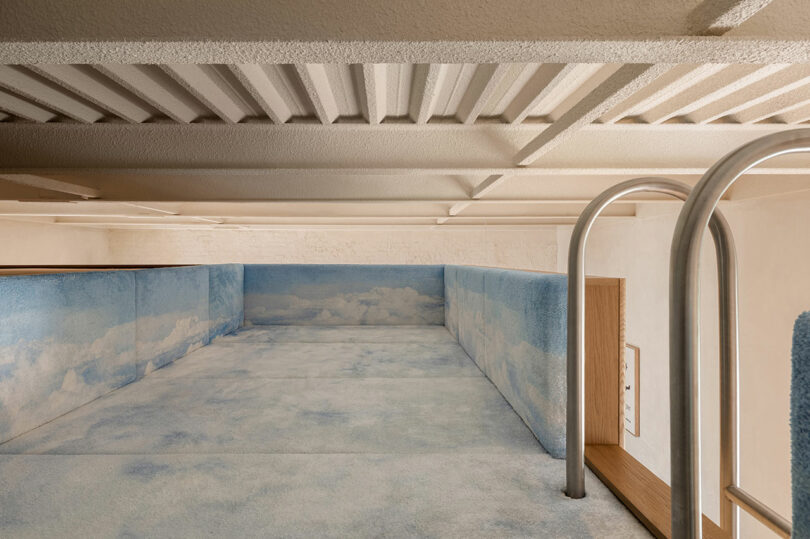 Interior of a lounge space upholstered entirely in blue sky-and-cloud patterned fabric.
