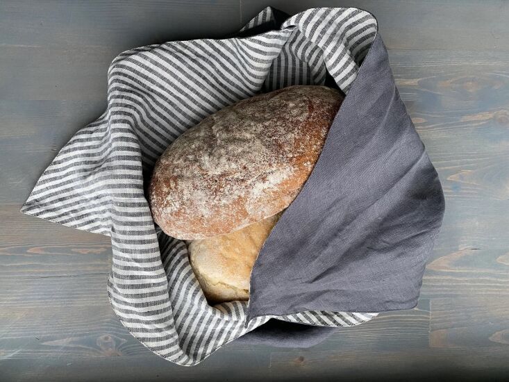 A double-layered linen bento bread bag with a square base and tied top ends.