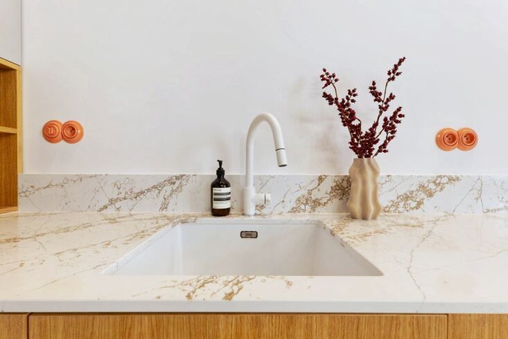 A modern kitchen in Czechoslovakia featuring vibrant green Katy Paty porcelain switches.