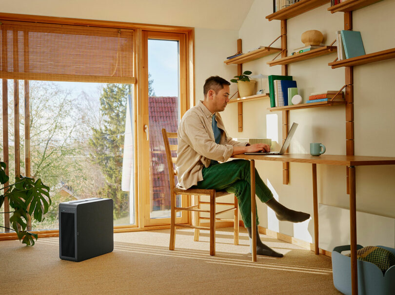 A man working on a laptop in a bright, modern home office.