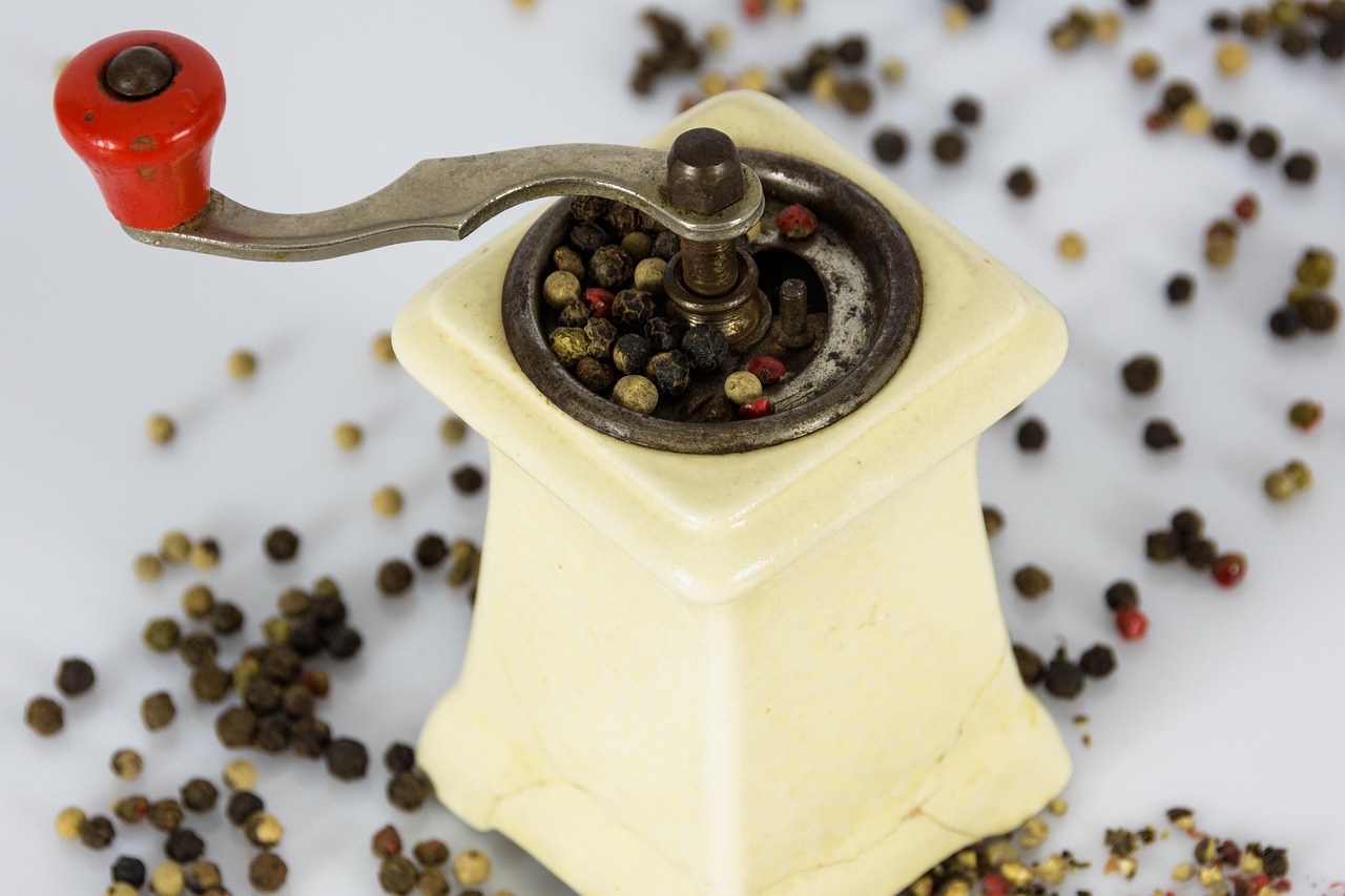 A variety of sculptural wooden salt and pepper mills arranged on a table.