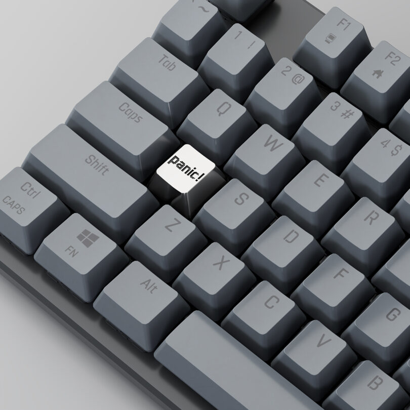 Close-up of a gray mechanical keyboard featuring a custom 'Panic' Esc key.