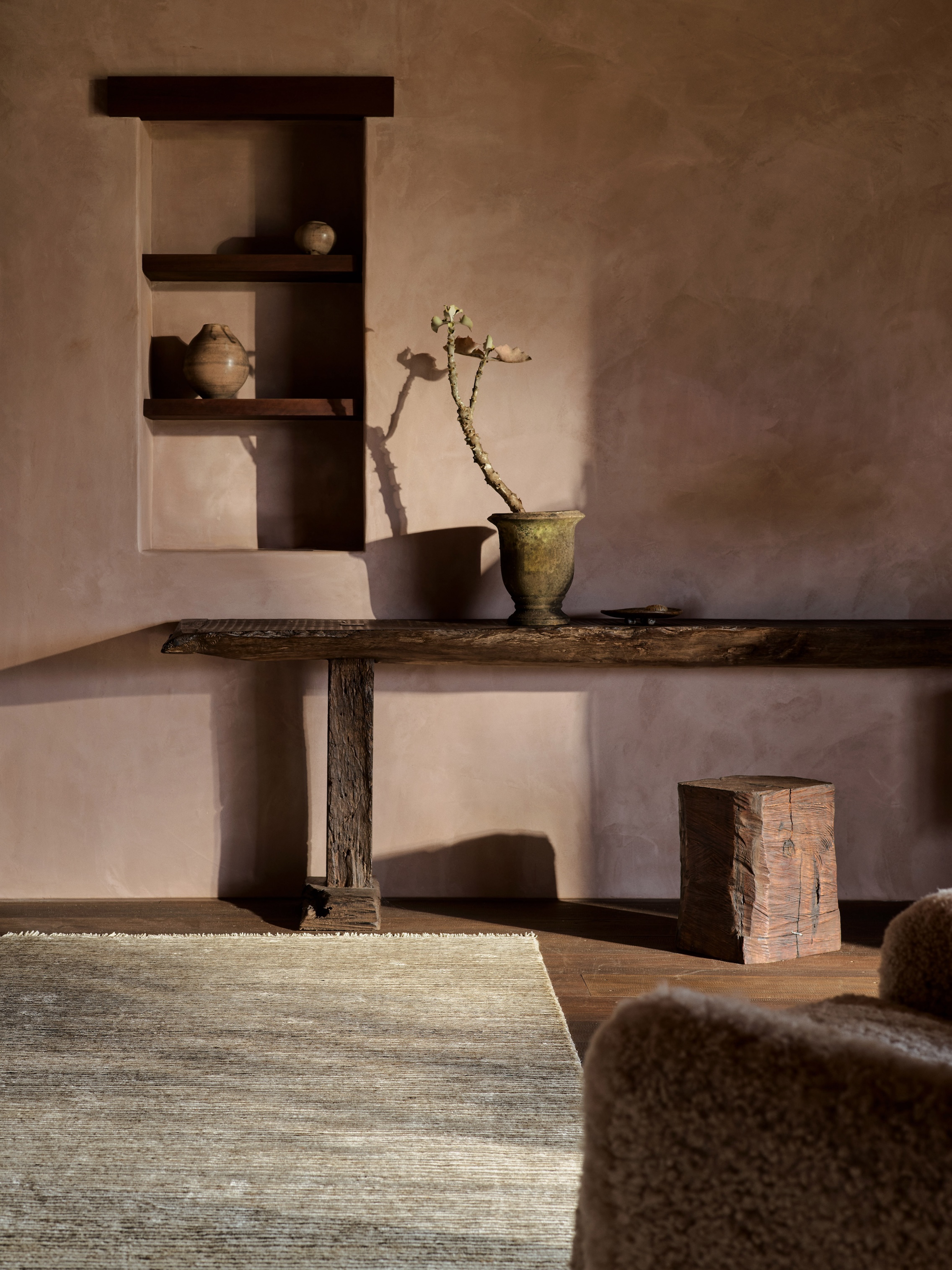 Interior shot featuring natural lime-mineral plaster walls and a textured earth-toned rug.