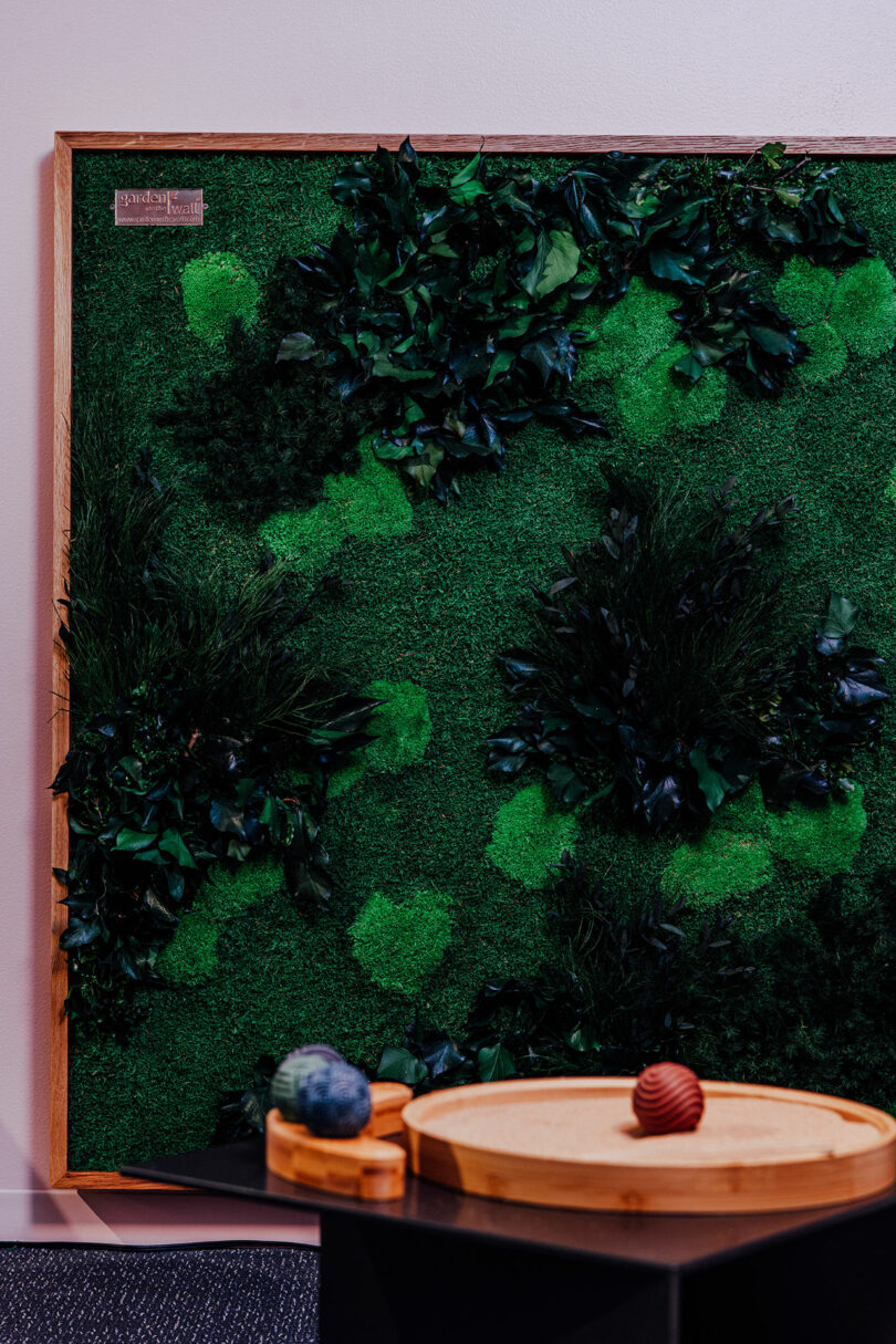 Framed green moss wall art displayed in a modern lounge setting.