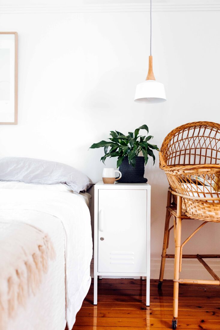 A 'The Shorty' locker used as a nightstand next to a bed.