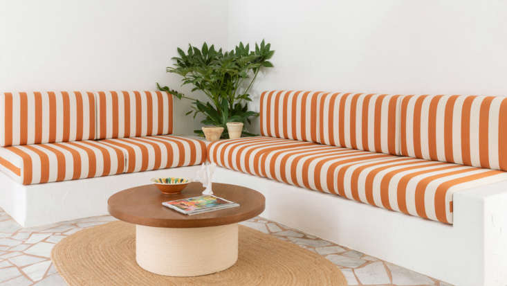 A built-in bench sofa featuring blue and white striped cushions at a hotel in France.