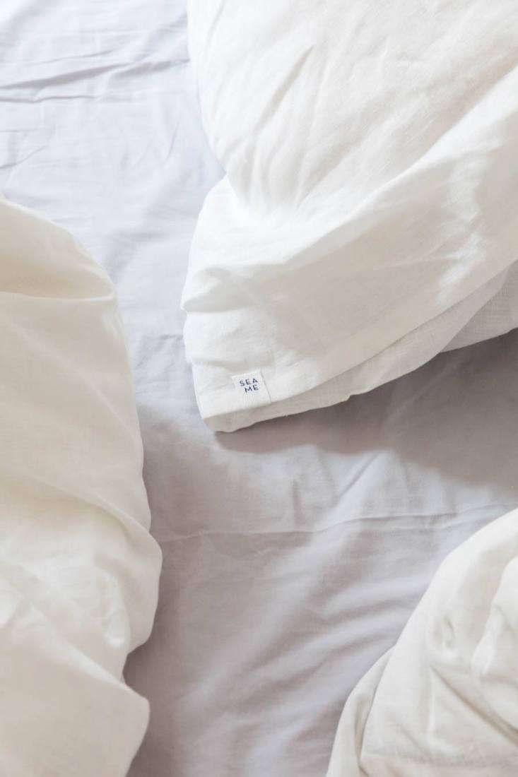Close-up of a Sea Me brand tag embroidered onto a linen pillowcase.