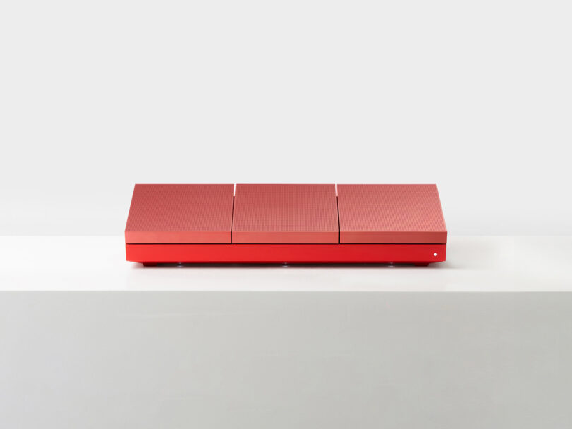 A red rectangular modular box with three distinct segmented lids.