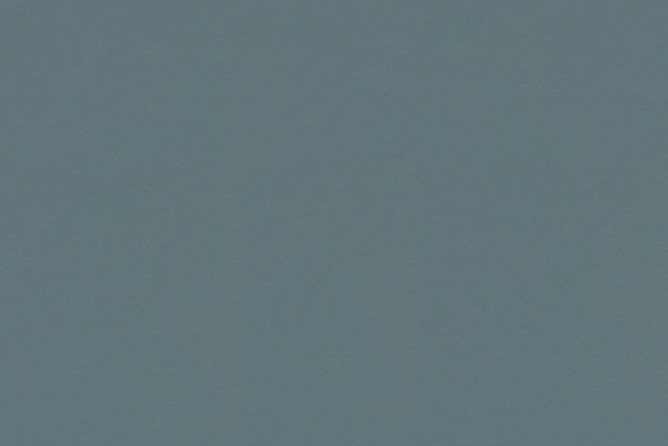 Deep blue Marmoleum flooring meeting the green base of a kitchen island.
