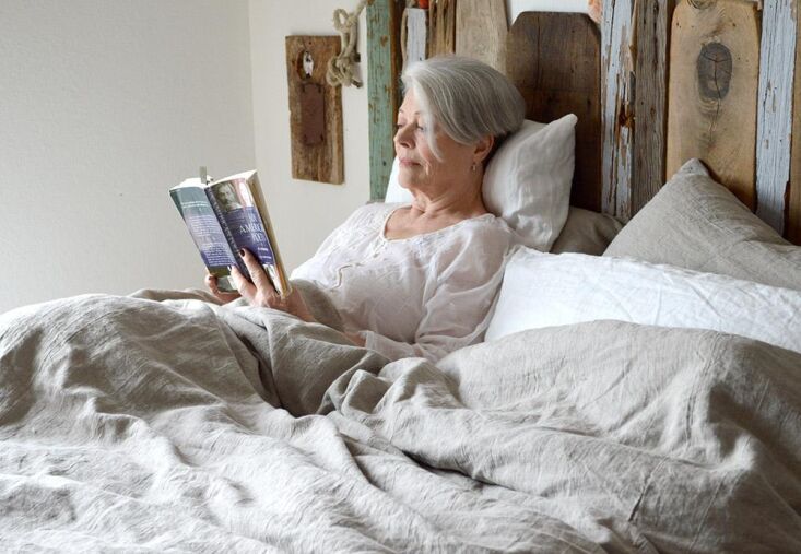 Soft, layered linen bedding in neutral tones showcasing the texture of Rough Linen's Orkney fabric.