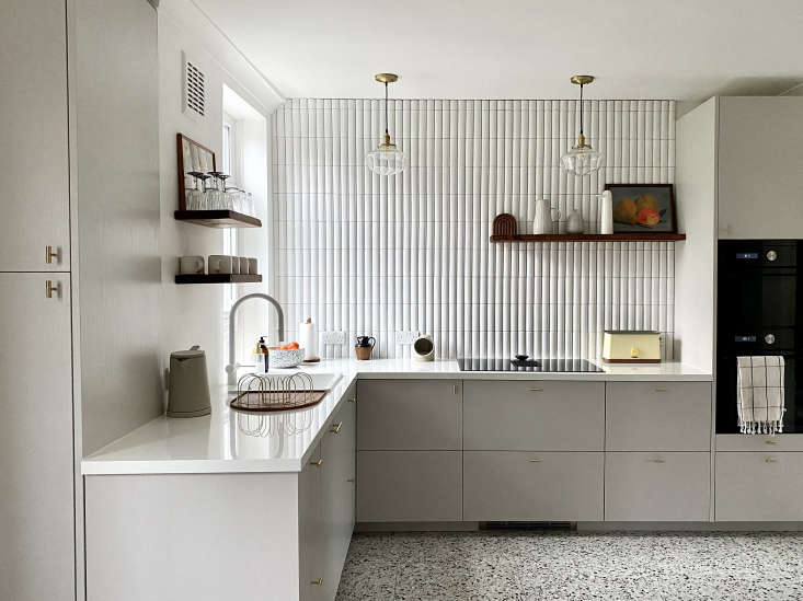 A wide shot of a London kitchen with terrazzo floors and mid-century inspired cabinetry.