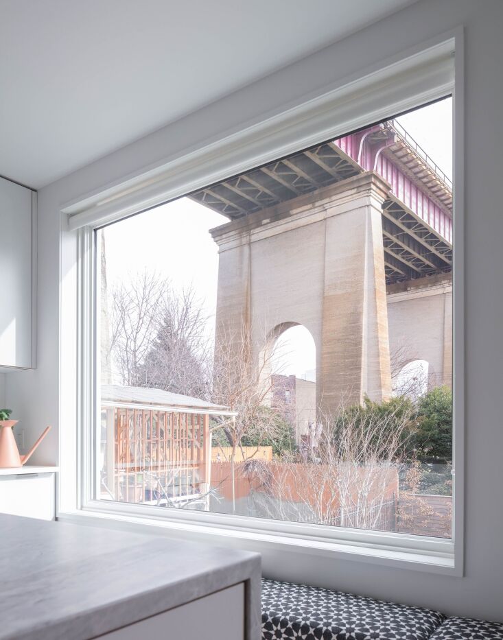 A modern window seat framed by a new Marvin double-glazed window overlooking the Hell's Gate Bridge.
