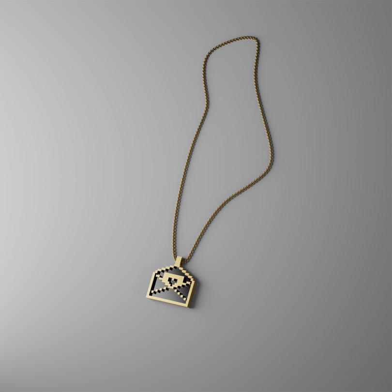 Gold chain necklace with a pixelated skull pendant.