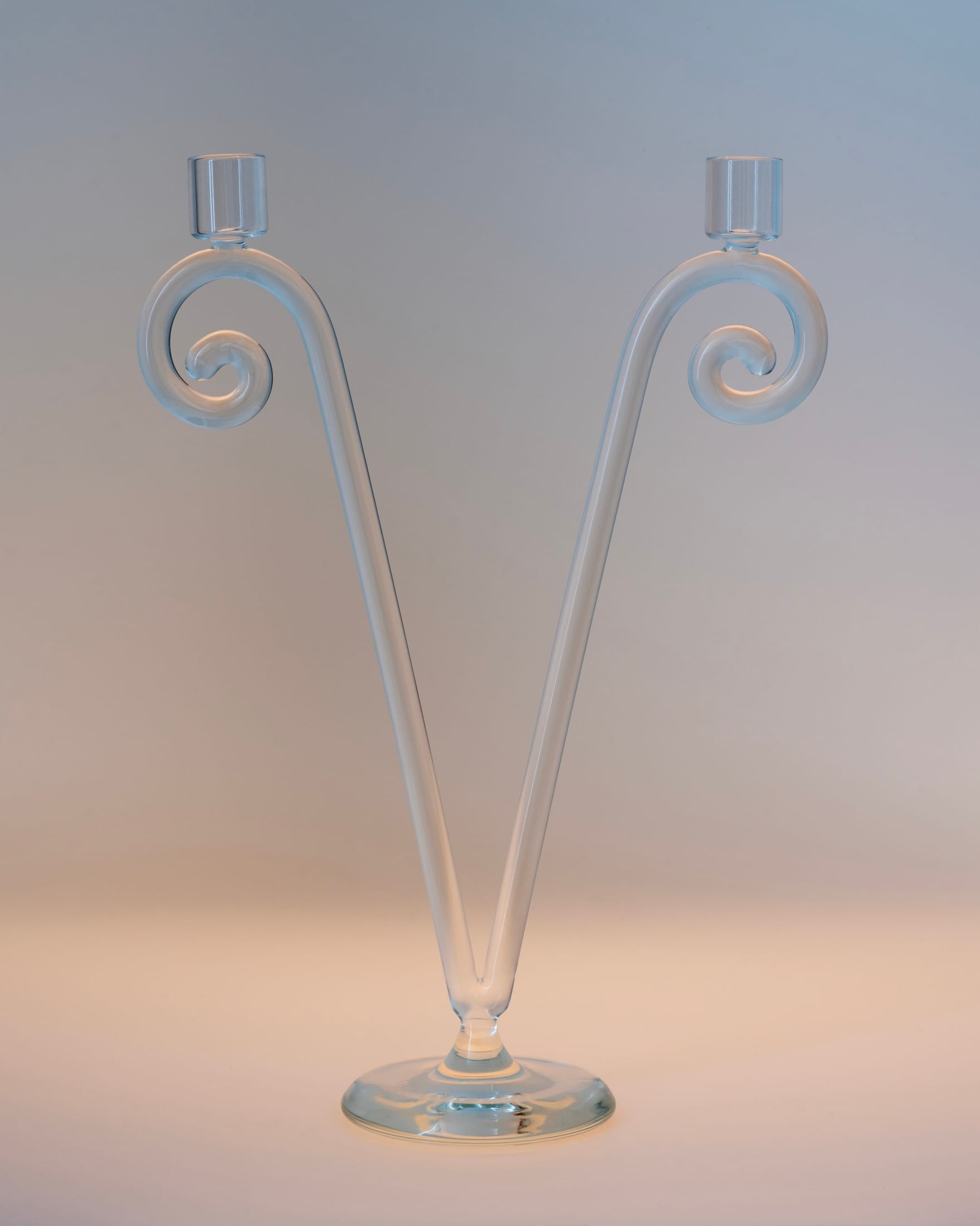 A pair of purple and amber spiral glass candleholders with tall tapers.