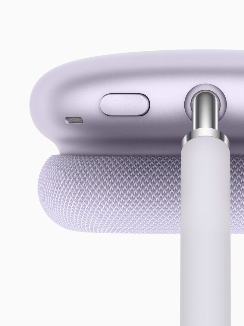 Close-up of the lavender AirPods Max 2 with a USB-C charging cable plugged into the bottom port.
