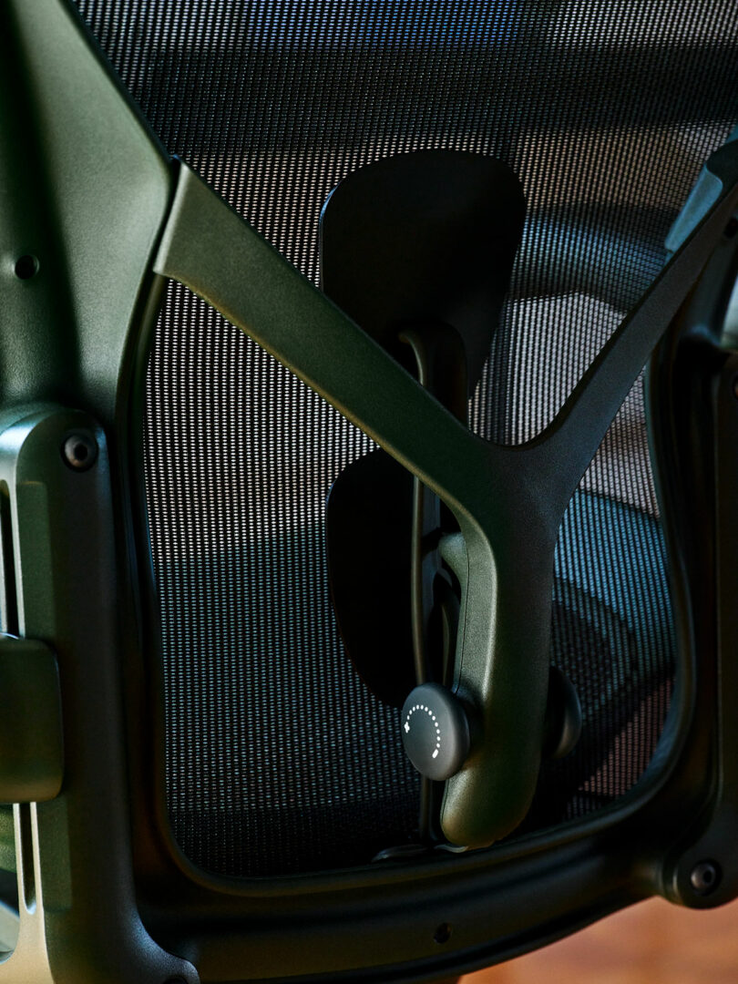 Detailed view of the lumbar support adjustment knob on the back of an Aeron chair.