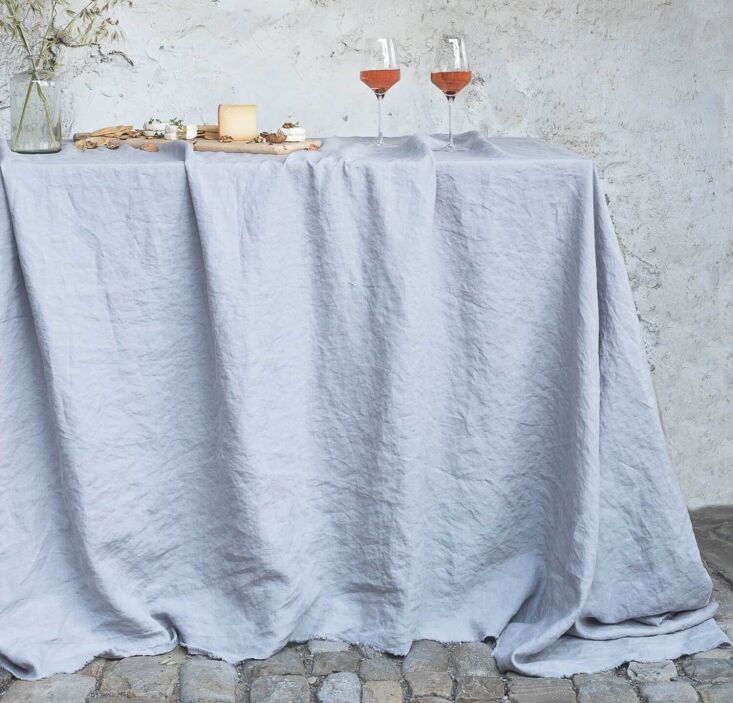 A minimalist table setting featuring natural linen napkins and kitchen textiles.