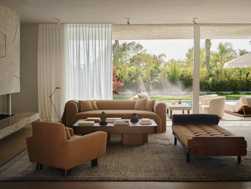 Modern living room with floor-to-ceiling glass windows overlooking a swimming pool and lush garden.