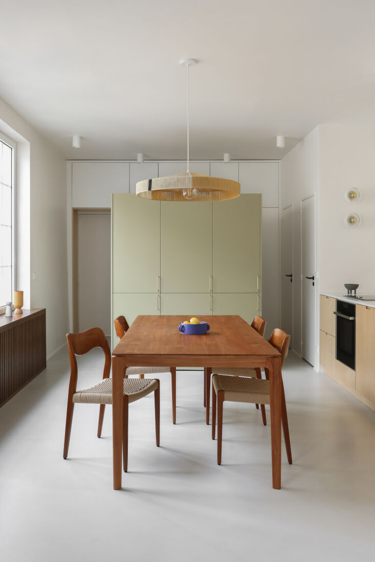 An open-plan living area and kitchen featuring Baltic birch cabinets with recessed handles.