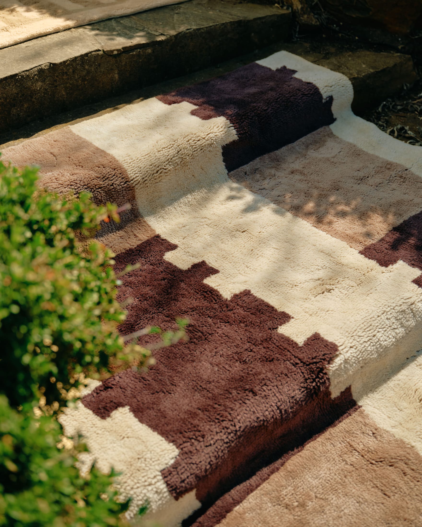 A rug with a geometric masonry-inspired pattern in soft brown and sandstone colors.