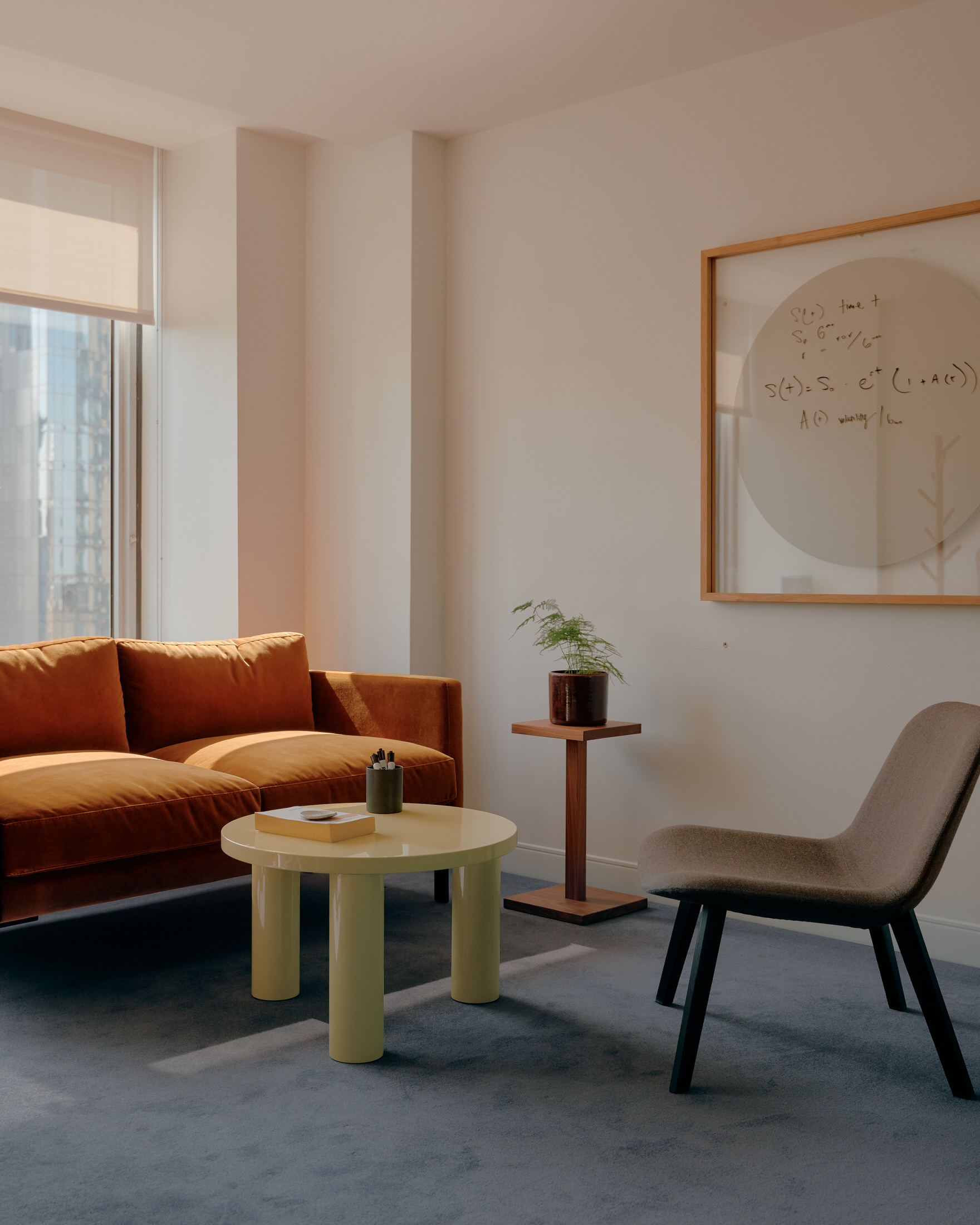 A large rhombus-shaped wooden boardroom table surrounded by modern office chairs under a concrete ceiling.