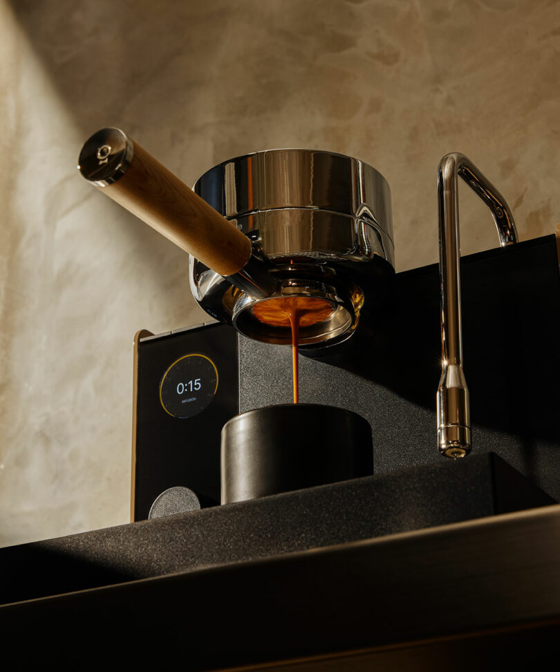 Espresso pouring from the portafilter into a cup with a digital timer display showing 15 seconds.