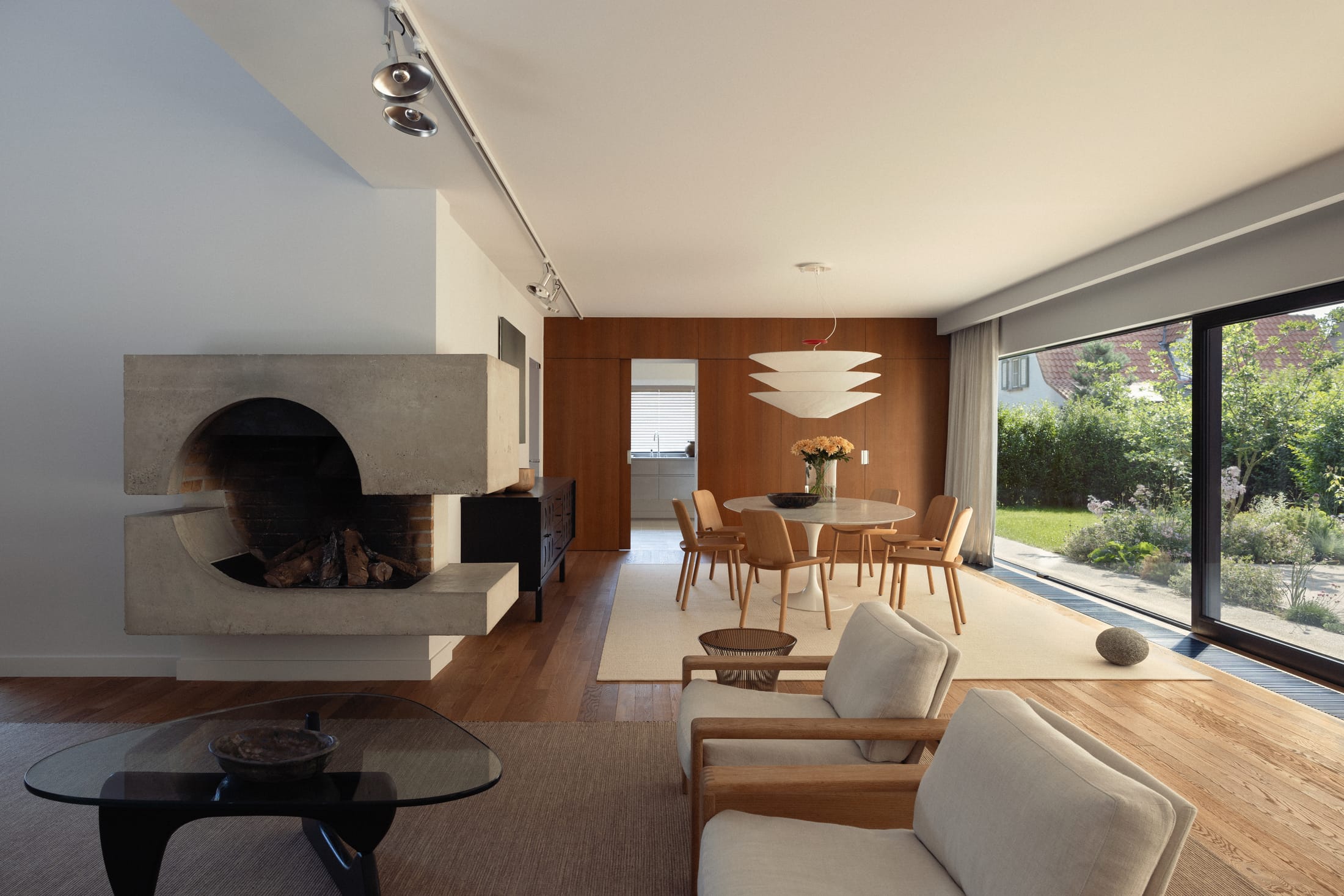 A sculptural concrete fireplace integrated into a minimalist white living space.