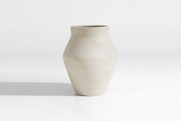 A large sand-colored fiberstone planter with a textured, weathered finish.