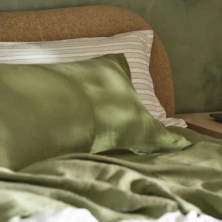 Washed Linen Core Sheet Set in Fresh Moss green, neatly folded on a bed.