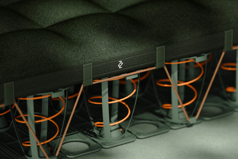 A cross-section view of the mattress showing the green top layer and internal orange spring mechanism.