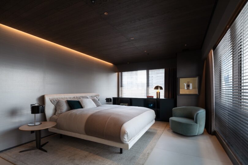 Sophisticated master bedroom with dark-toned integrated storage and mood lighting.