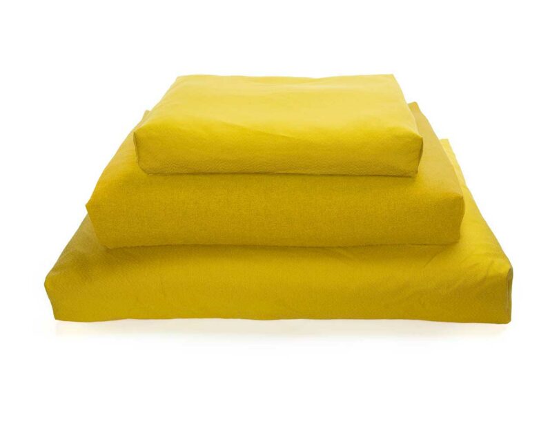 Three rectangular Oksa dog beds in different colors stacked to show variety.