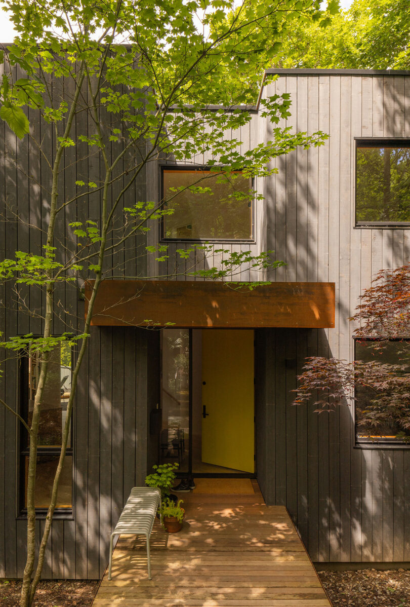 Close-up of vertical wooden siding and large black-framed windows on a modern house.