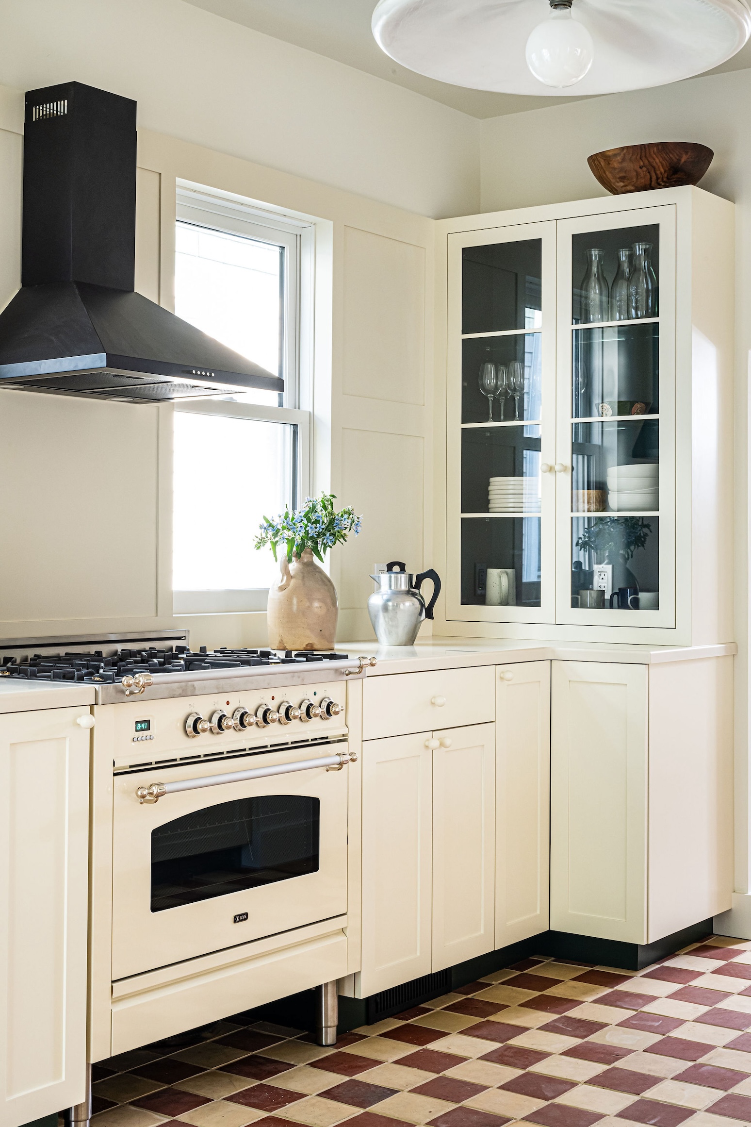 Close-up of an ILVE Nostalgie II range and Ancona pyramid hood integrated into custom wall paneling.