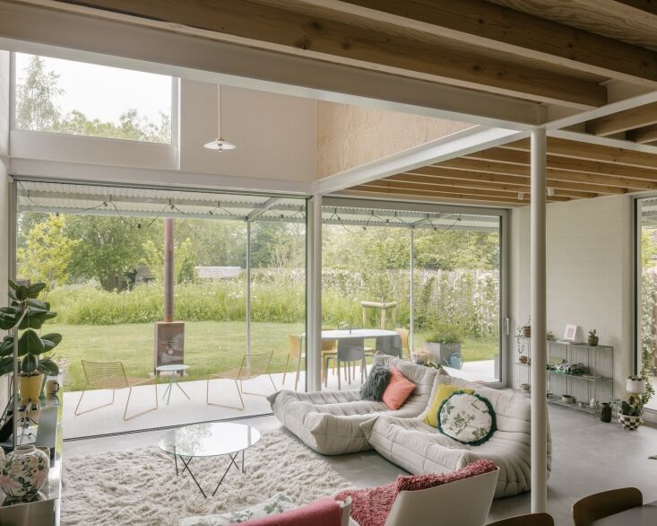 Interior of House Eva featuring green and white color palette with Togo lounges and plywood walls.