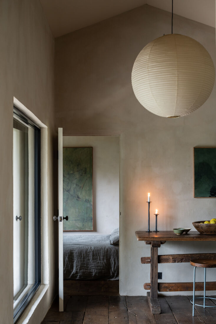 A view from the hallway into the bedroom featuring textured Bauwerk Seed limewash walls.