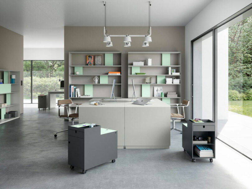 Modern open-plan office featuring minimalist furniture and mobile storage units.