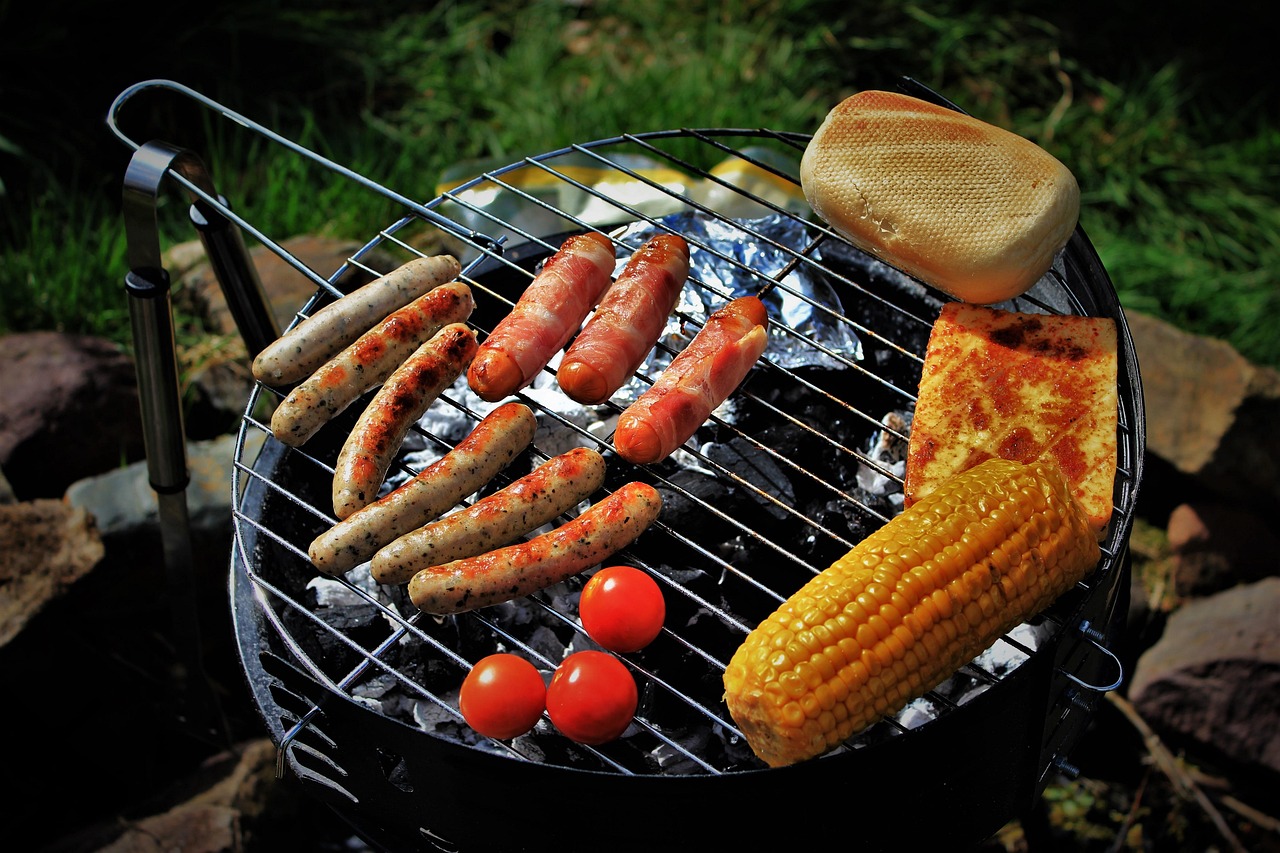 A person using a grill scraper to clean stainless steel grates.