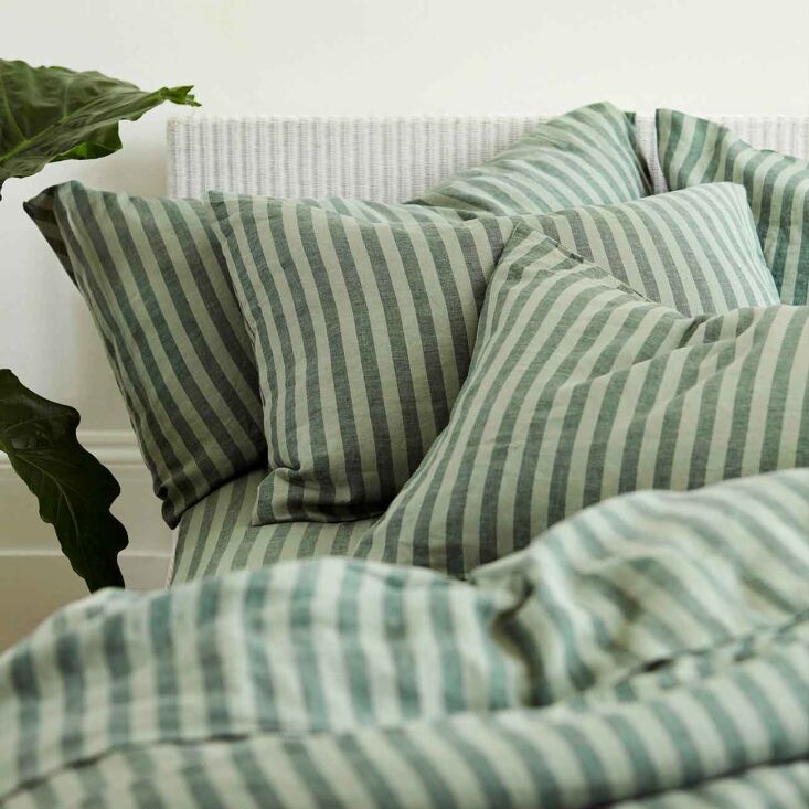 Deep Pine Green Pembroke Stripe Linen Pillowcases resting on a bed.