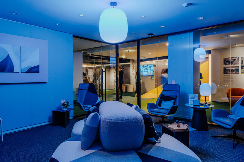 A modern lounge with blue ambient lighting and semi-private seating areas.