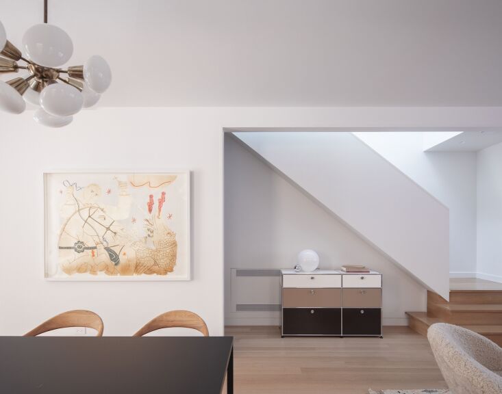 A bright living and dining area featuring rift sawn white oak floors and Benjamin Moore White walls.