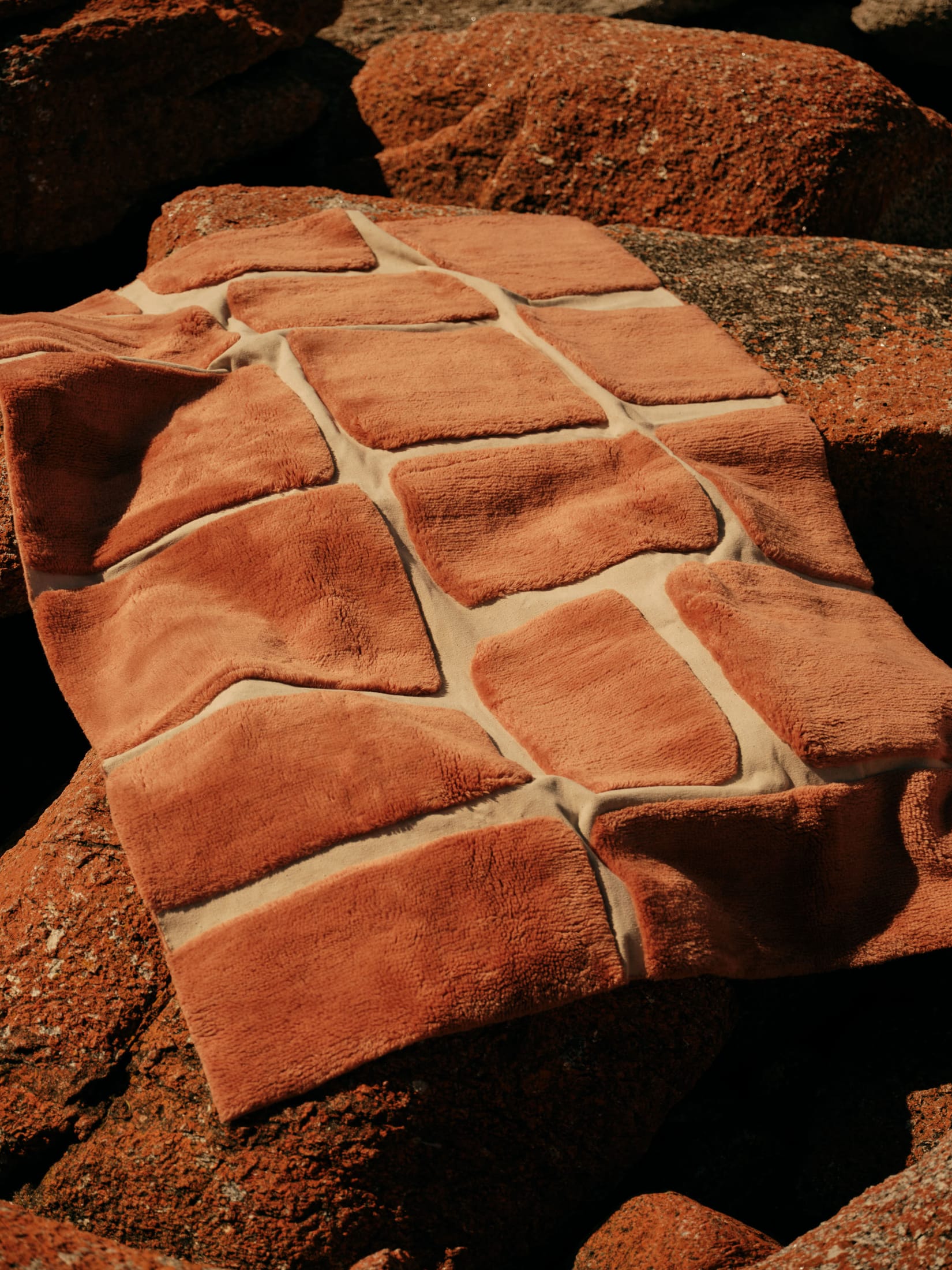 Detail shot of the Ember Rust rug featuring warm orange and red earthy tones.