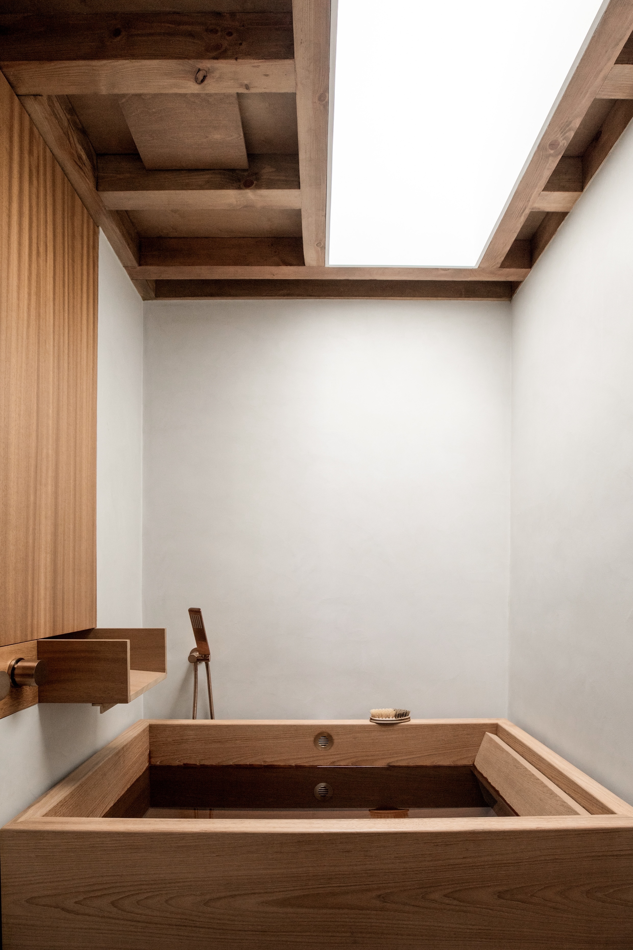 A custom-built Japanese soaking tub positioned under a large skylight.