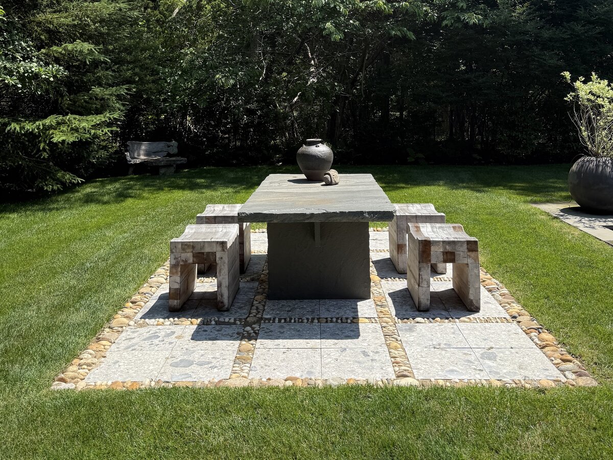 A modern stone patio in Amagansett with clean lines integrated into a natural landscape.