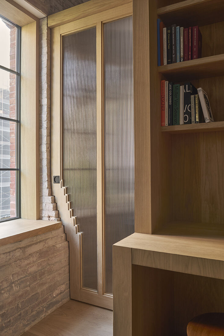 Close-up of a custom door frame designed to interlock with the profile of an original masonry brick wall.