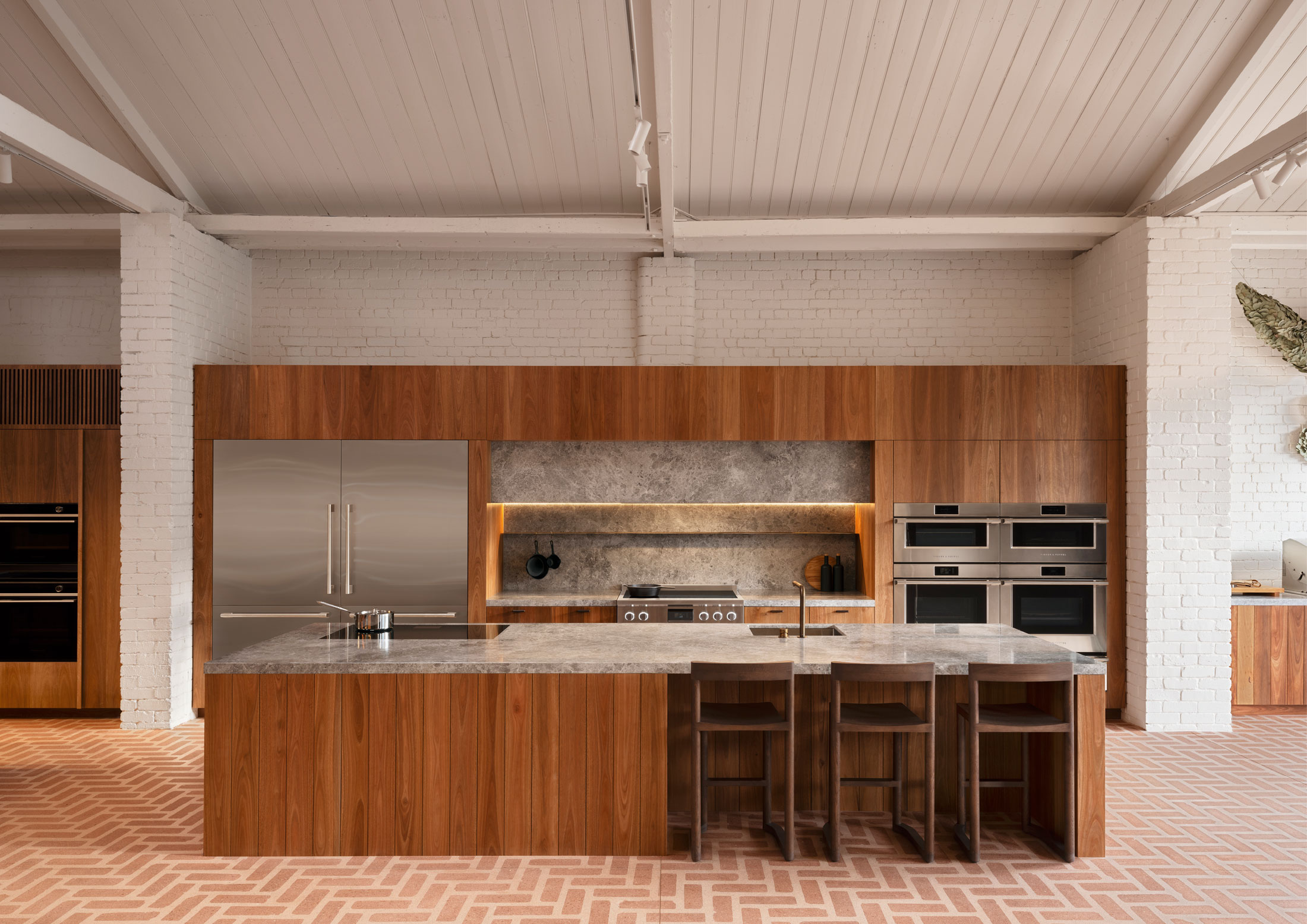 A professional-style kitchen setup featuring high-grade stainless steel appliances and wood accents.