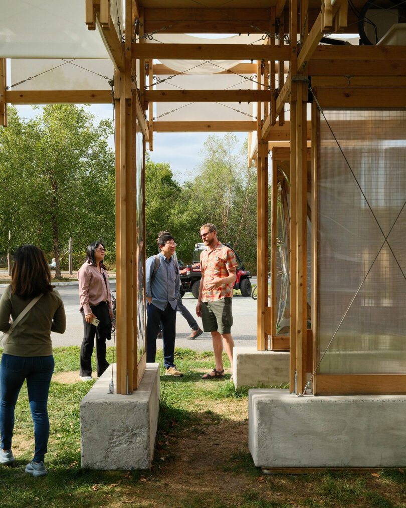 A group of people standing and talking next to the KlimaKover installation on Governors Island.