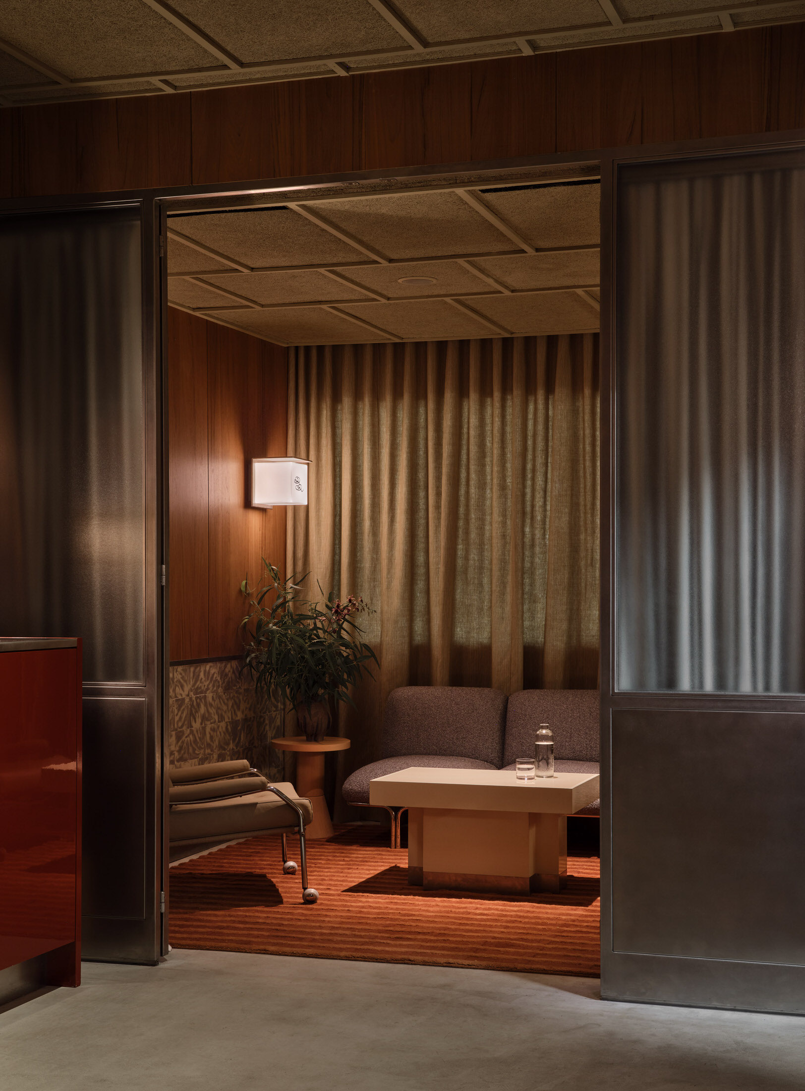 A corner of the bar featuring striped curtains and a relaxed lounge-style seating arrangement.