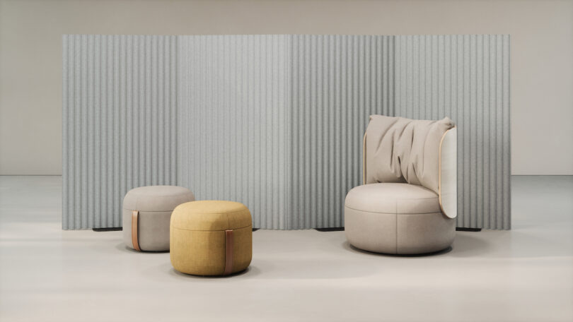 A modern seating area with a light grey fluted privacy screen behind a beige chair and ottomans.