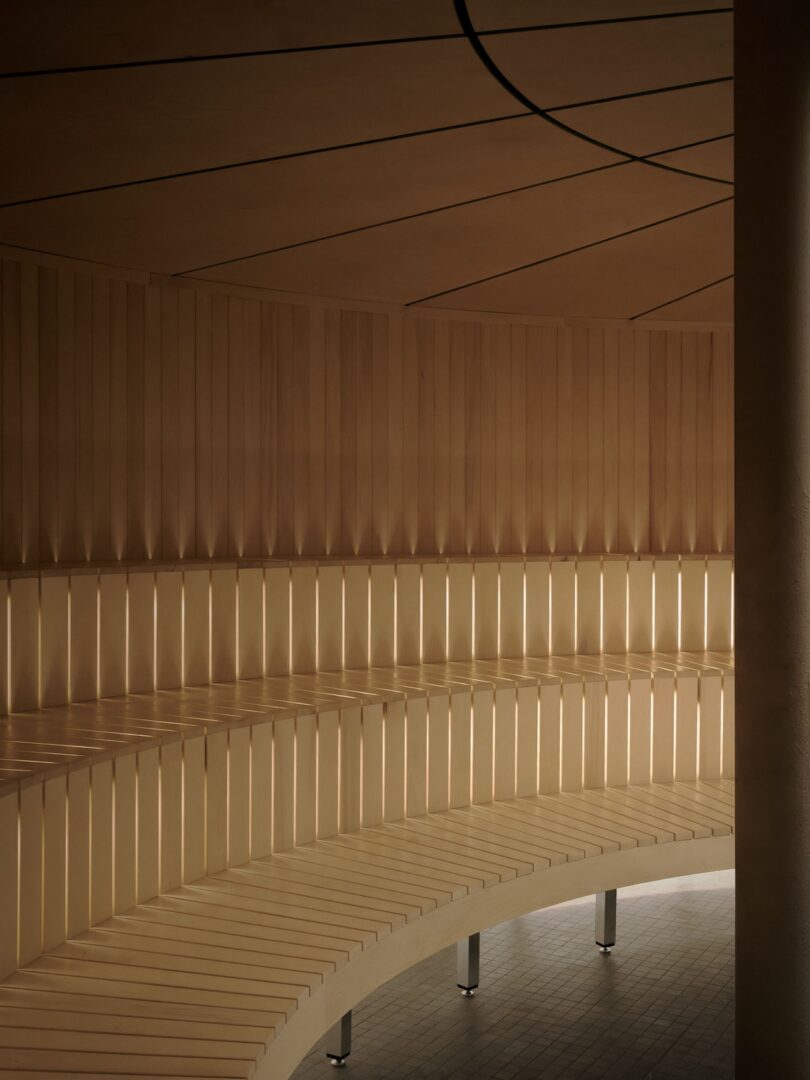 Close-up of curved wooden slat walls with soft, indirect backlighting.